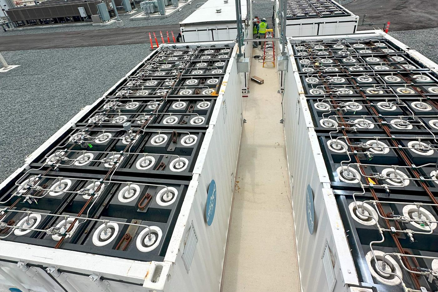 Overhead view of modular hydrogen storage containers showing rows of composite pressure vessels and piping systems, part of a large-scale clean energy and hydrogen infrastructure installation.